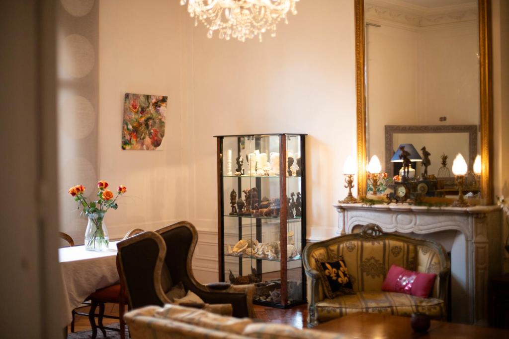 a living room with a chair and a mirror at Villa MONIKA in Dieppe