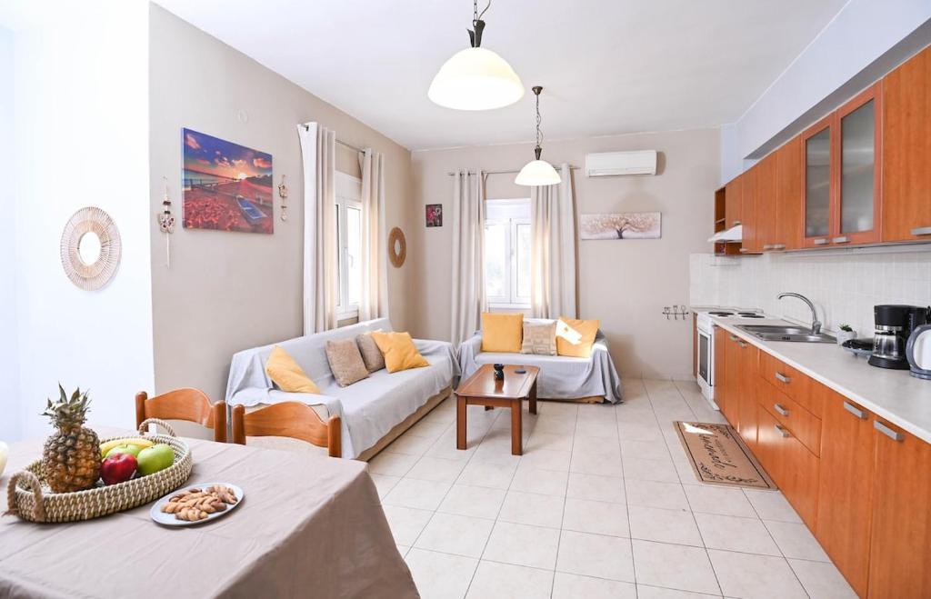a kitchen and a living room with a couch at Efrosini & Ioanna Apartment in Ligaria