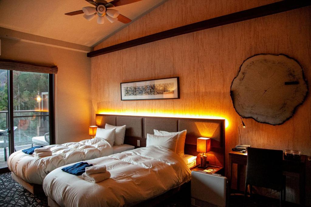 a hotel room with two beds and a window at ホテル風の山 in Iida