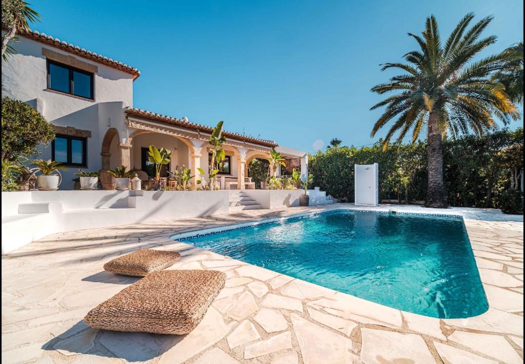 a swimming pool in front of a house at La Finca Blanca Javea in El Tosalet