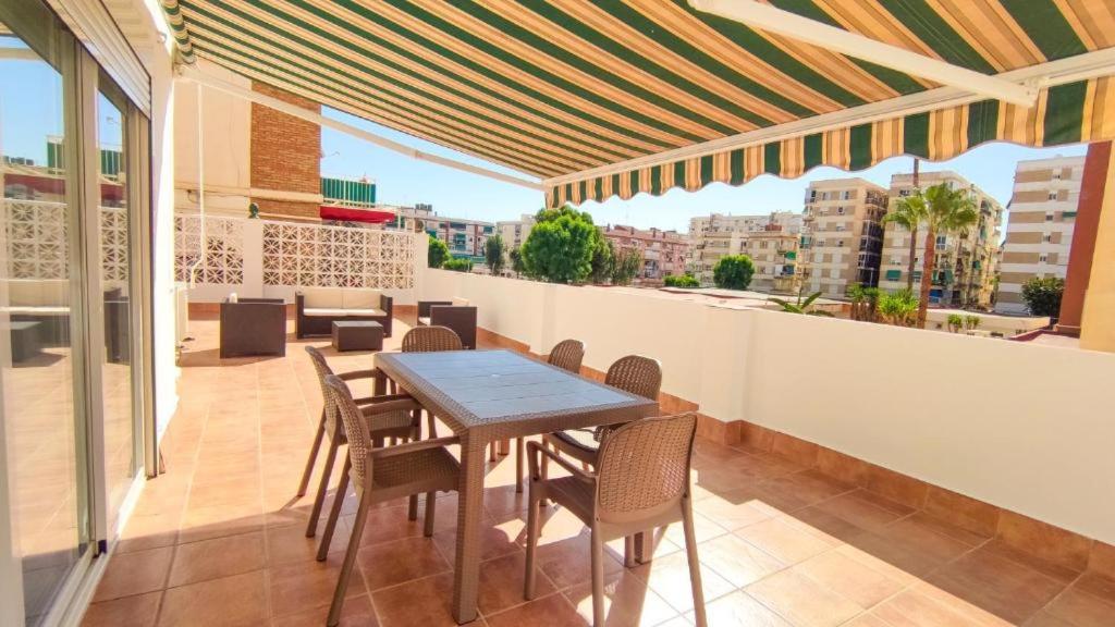 a patio with a table and chairs on a balcony at La Terraza de María P in Torre del Mar