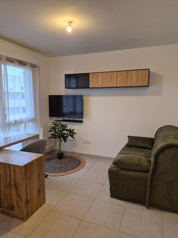 a living room with a couch and a table at Studio avec parking privé - Proche écoles & hôpital - Valence in Valence