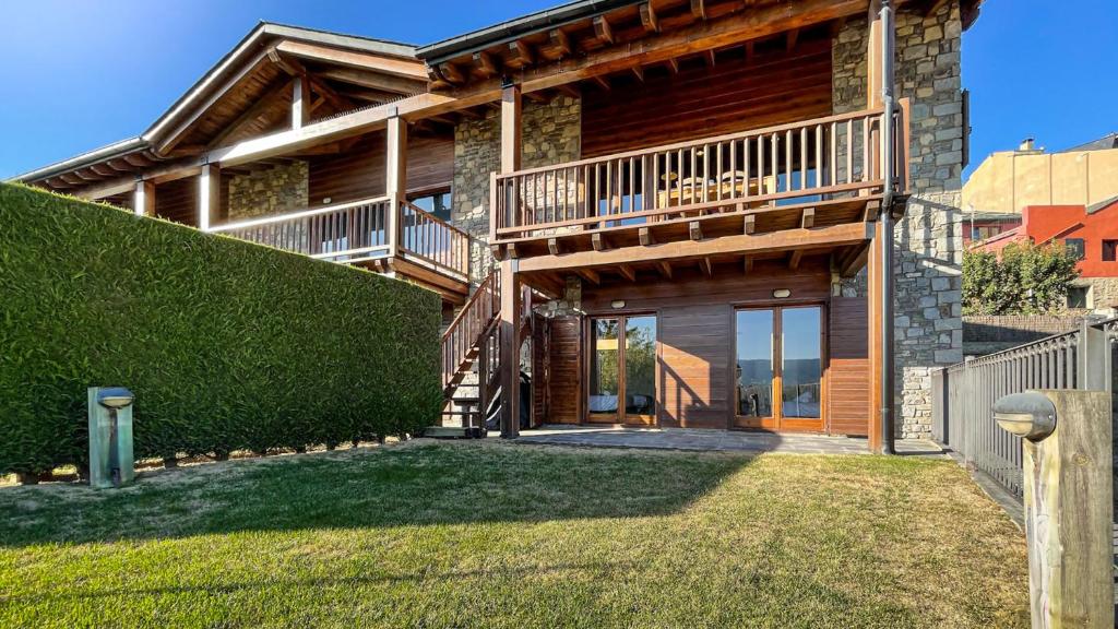 a log house with a balcony and a yard at Cal Vilaldach in Llivia