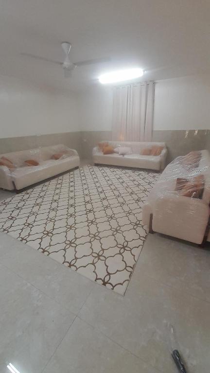 three beds in a room with a tiled floor at Room Quriyat in Ramlah