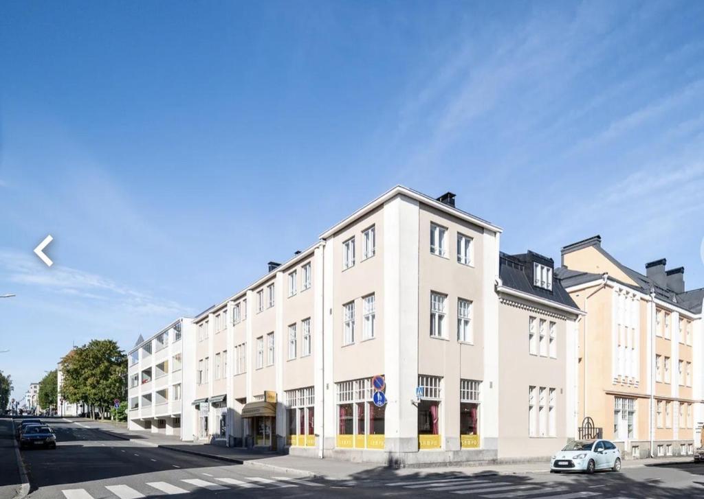 a large white building on the side of a street at Tunnelmallinen saunallinen ullakkohuoneisto Ravintola Sampon yläkerrassa in Kuopio