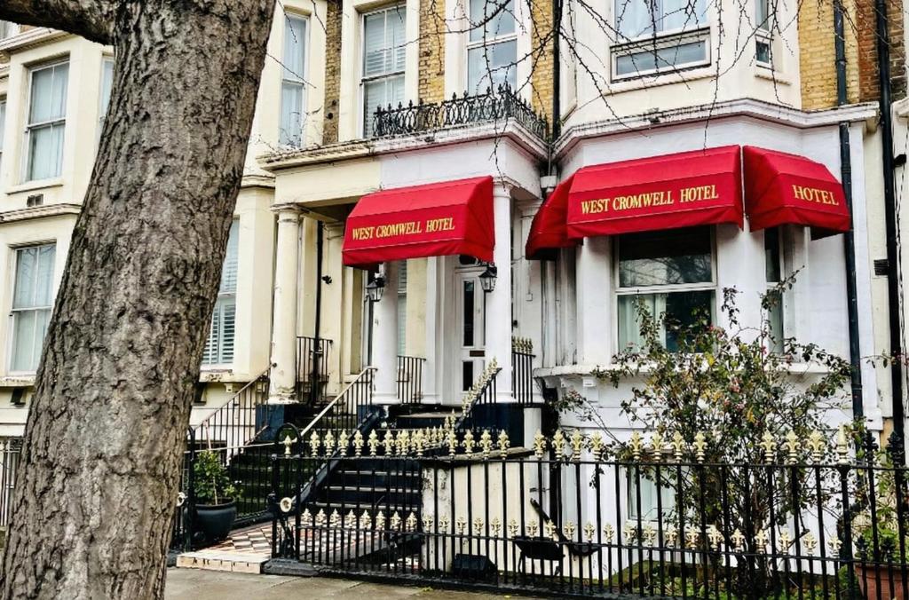 a house with red umbrellas on the front of it at West Cromwell Hotel in London