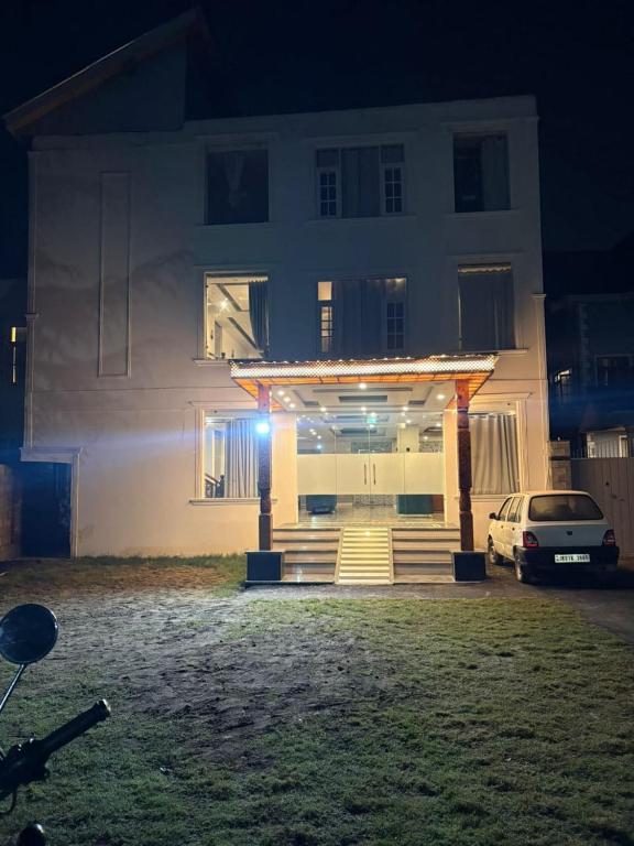 a white house with a car parked in front of it at Hotel Town Star in Srinagar
