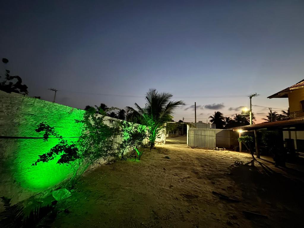 a green fence in front of a yard at night at Pousada Raios do Sol in Amontada