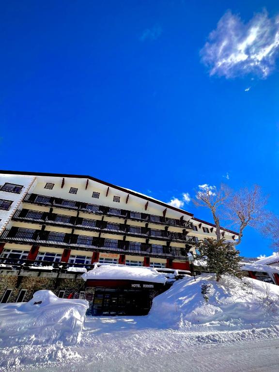 ein großes Gebäude mit Schnee davor in der Unterkunft Hotel Kodama in Yamanouchi
