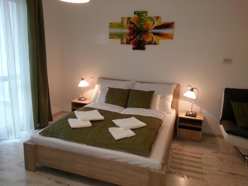 a bedroom with a bed with two pillows on it at Downtown Apartment Miskolc in Miskolc