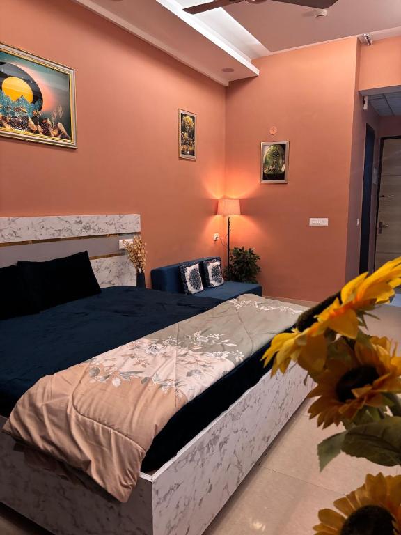 a bedroom with orange walls and a large bed at Good vibes only gaur city center studio apartment in Ghaziabad