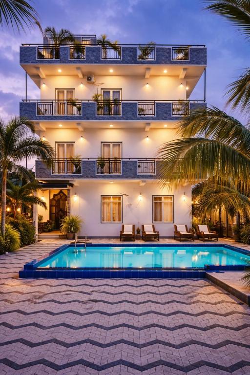 a villa with a swimming pool in front of a building at Blue Diamond Resort in Trincomalee