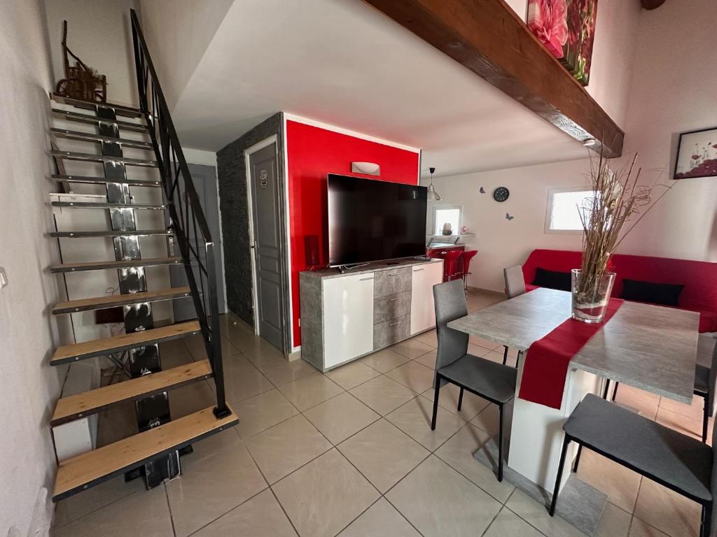 un soggiorno con tavolo da pranzo e televisione di Location Luccini a Saintes-Maries-de-la-Mer