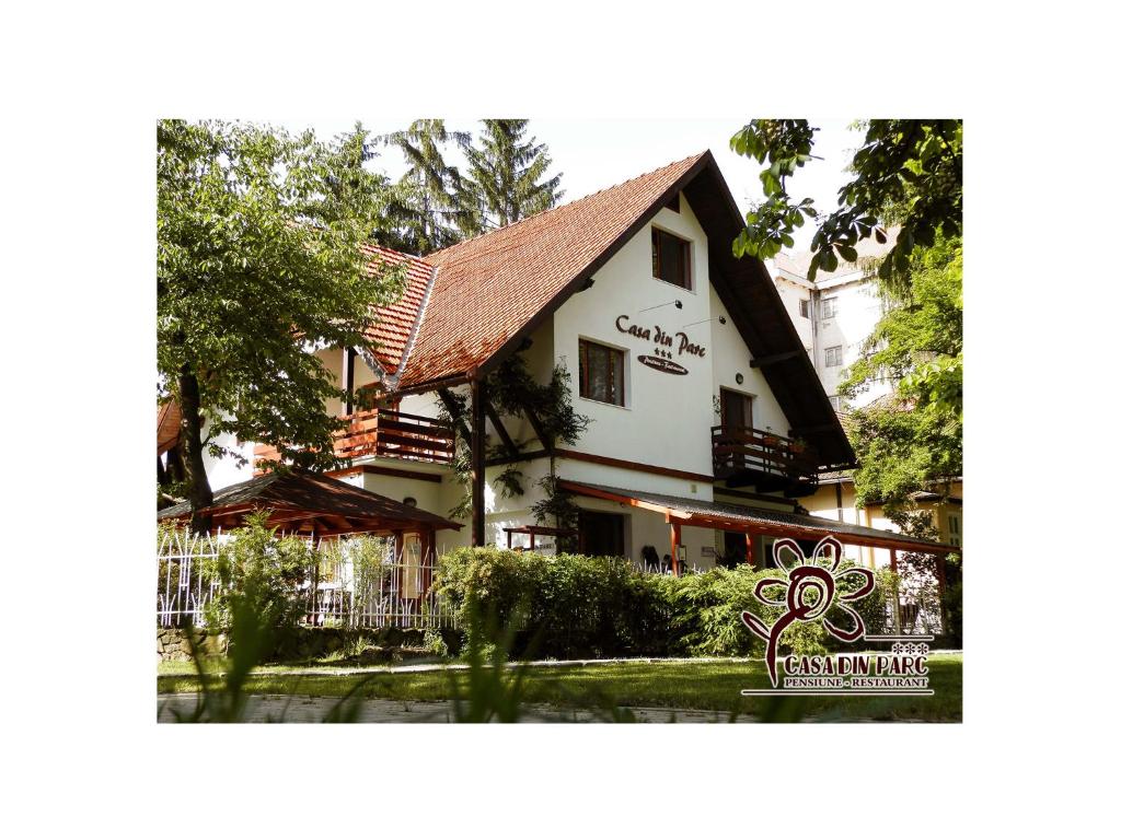 a white building with a fence in front of it at Casa din Parc in Covasna