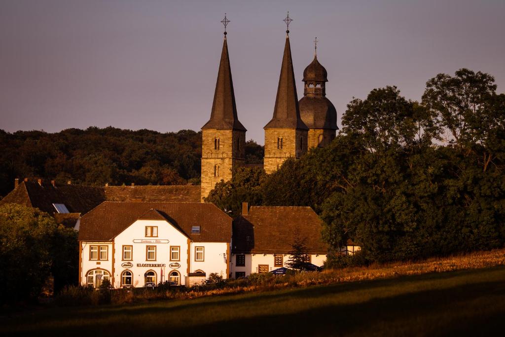 a white house in front of a castle at Klosterkrug Marienmünster in Marienmünster