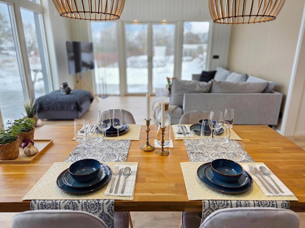 a dining room table with plates and glasses on it at Nybyggt hus med 3 sovrum, jacuzzi och närhet till strand in Bergkvara