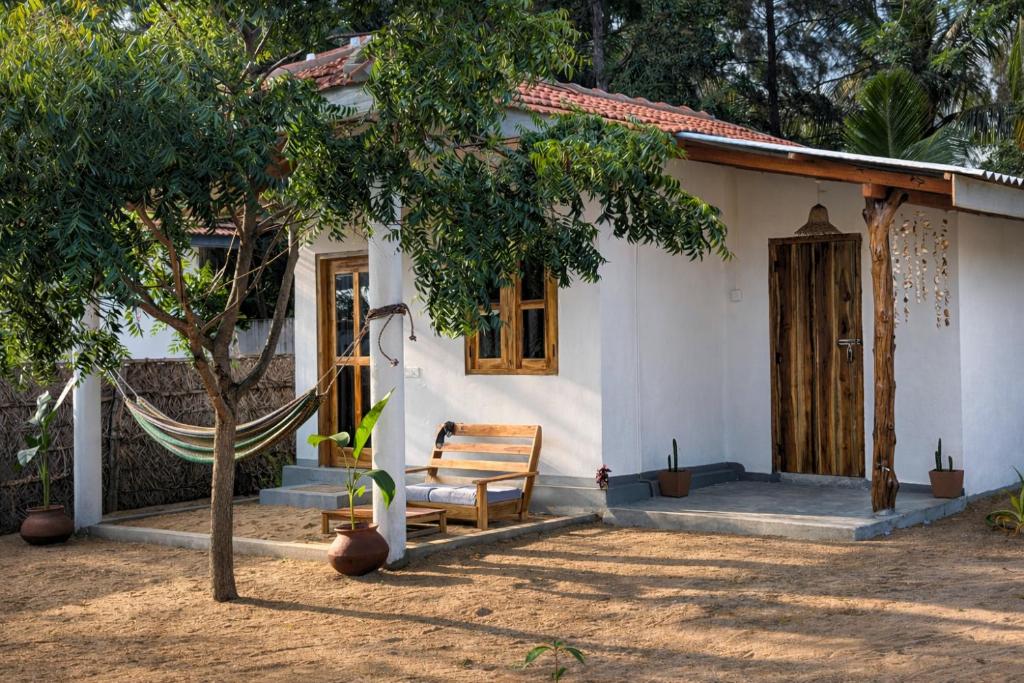 a house with a hammock in front of it at Inara Stay in Arugam Bay