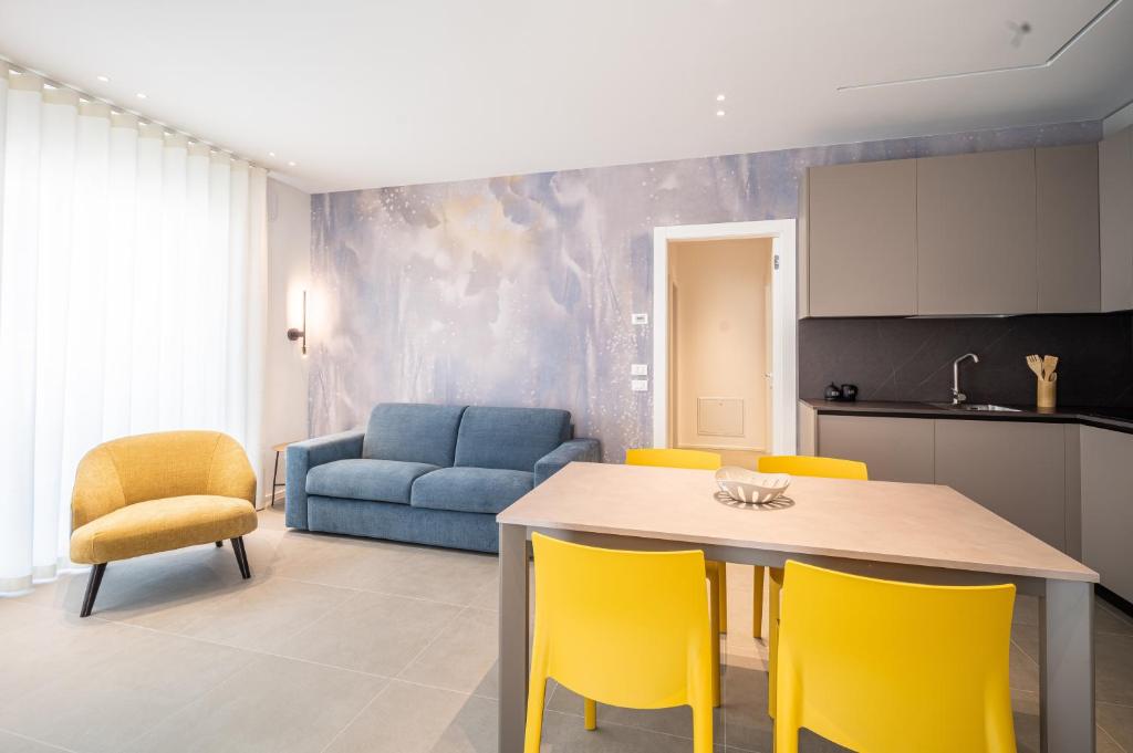 a kitchen and living room with a table and yellow chairs at A&G Blue flat in Cavallino-Treporti