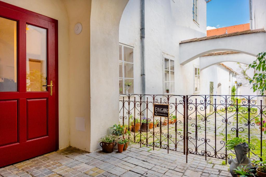 a red door of a building with potted plants at Am Znaimertor in Retz