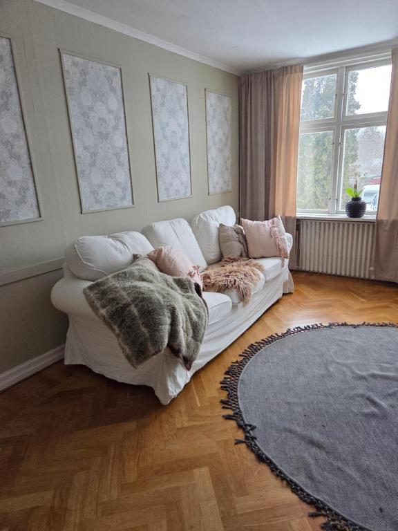 a living room with a white couch in a room at Blomstermåla in Blomstermåla