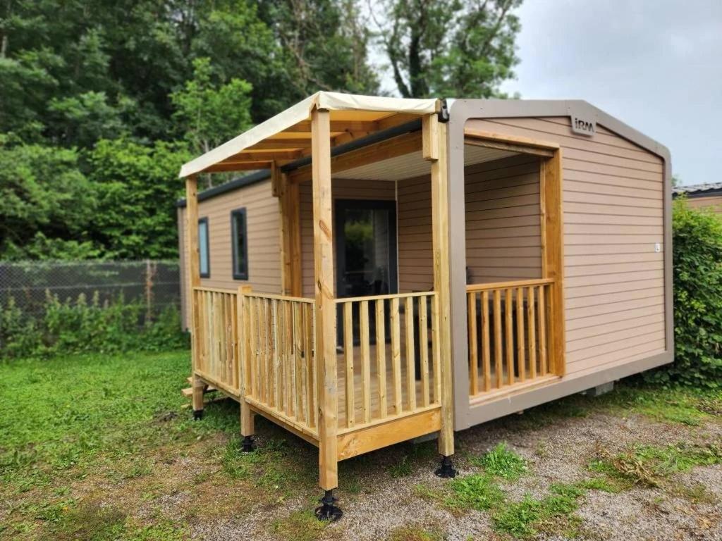 a large wooden cabin with a porch in a yard at ZEcamping 3 étoiles vue exceptionnelle et soirées animées in Gex