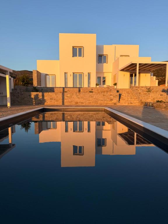 a reflection of buildings in a pool of water at Villa Kairos in Angairiá