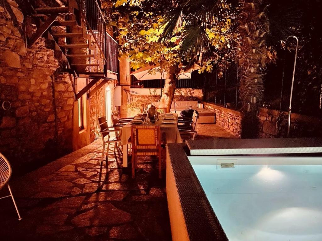 a patio with a table and a swimming pool at night at Lago Lounge & Pool in Stresa
