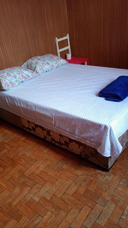 a bed sitting on top of a wooden floor at Pausada Regis in Lavras