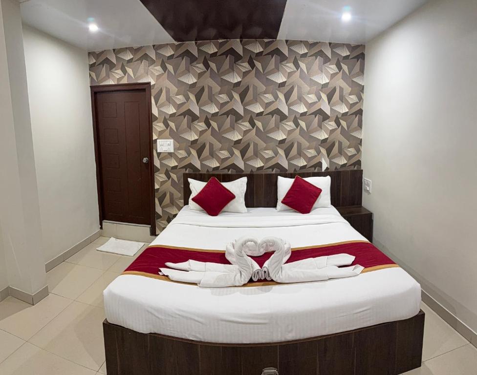 a bedroom with a bed with two white towels on it at Hotel Fortune 36 in Bangalore