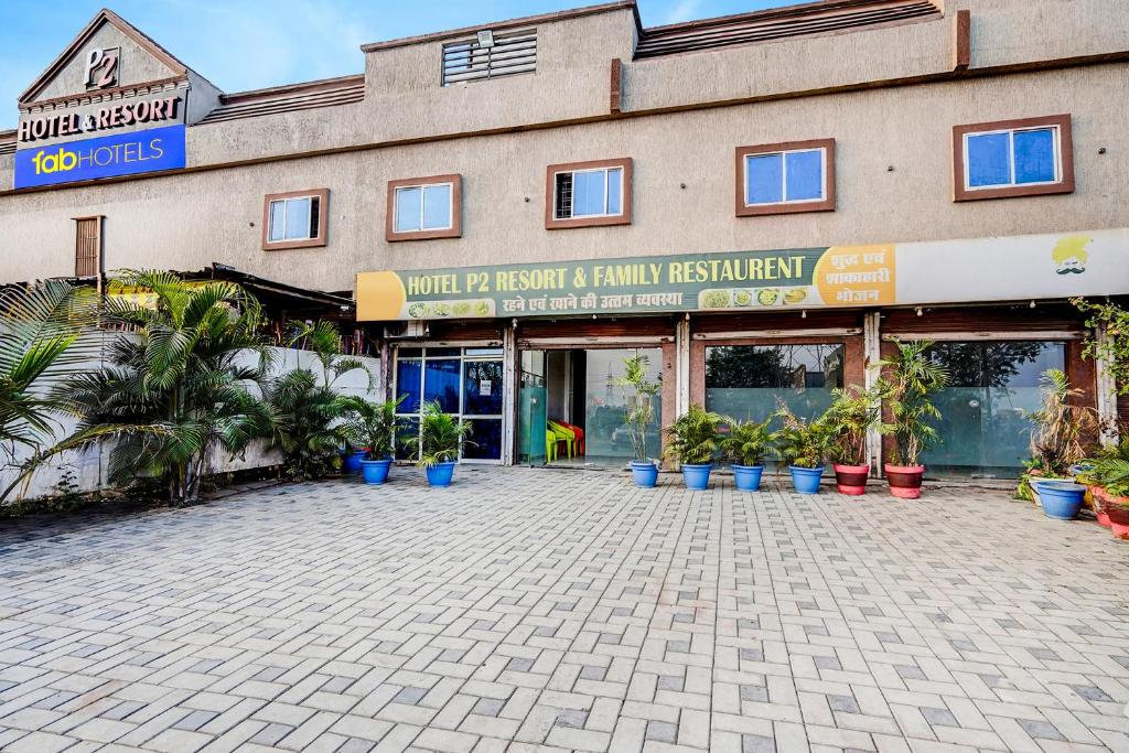 a building with a lot of potted plants in front of it at FabHotel P2 And Resort in Bhopal