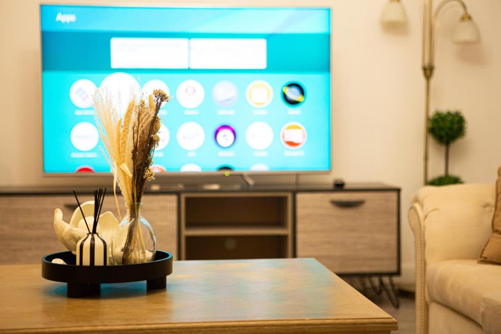 a living room with a table and a tv at Flat 2 Aylesbury Street in Bletchley