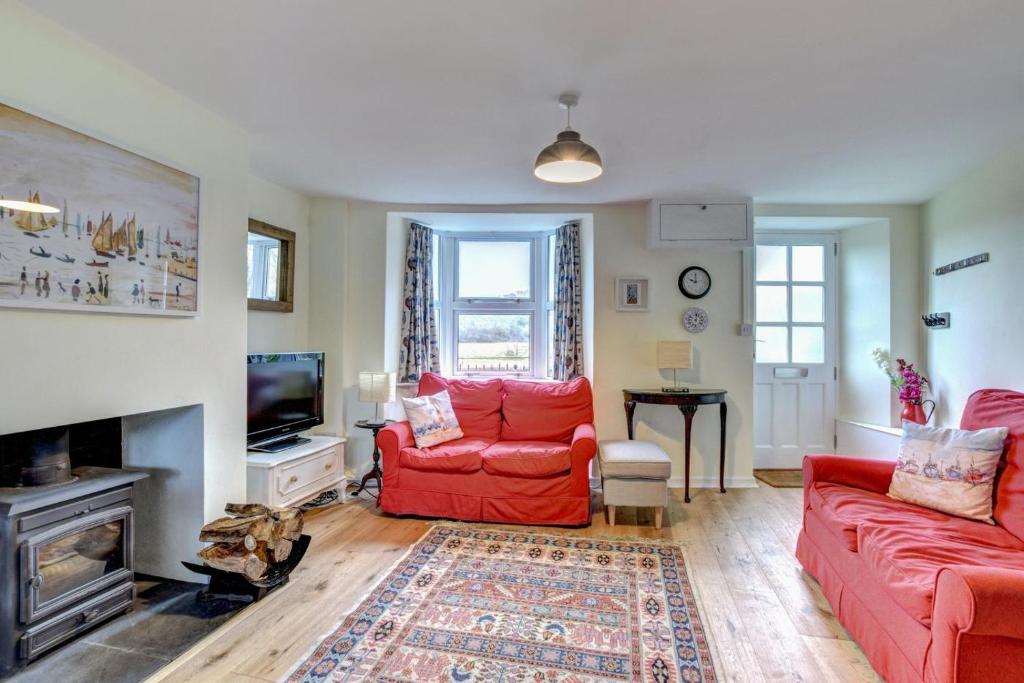 a living room with two red couches and a tv at 3 Bed in Bridport oc-wy401 in Bridport