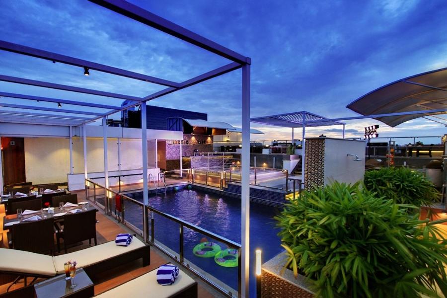 a restaurant with a pool on the roof of a building at Lavender Premier in Bangalore