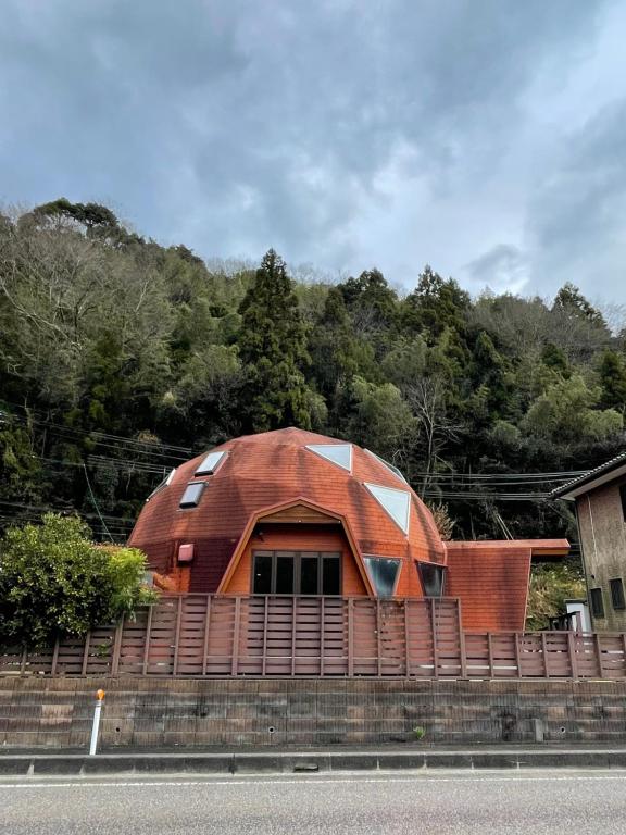 a building with a red roof on the side of a road at ゲストハウスフォレ in Kukumo