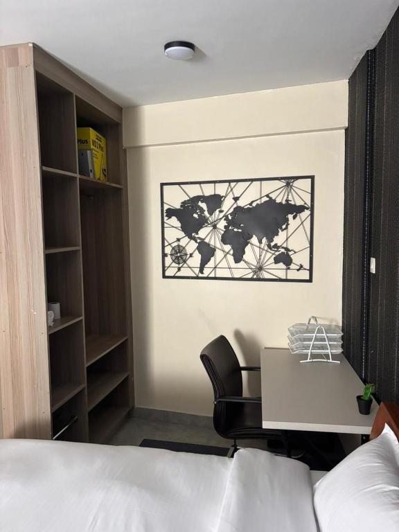 a bedroom with a bed and a desk and a chair at Sitati in Ruaka