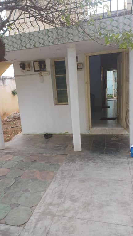 a white house with a porch and a door at Ganga Homestays in Tiruvannāmalai
