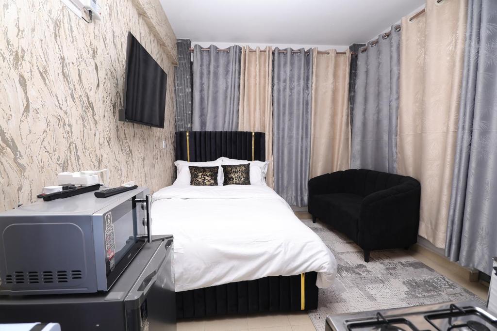 a bedroom with a bed and a tv and a chair at JS Urban Stays in Gatunga