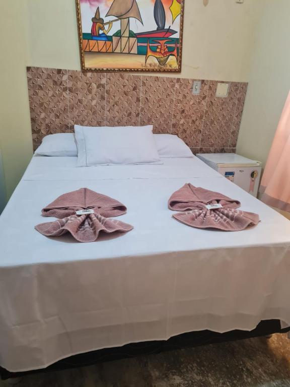 a bed with two towels on top of it at Porto Pousada in Ipojuca