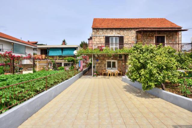 a house with a brick walkway in front of it at Studio apartment in town center in Stari Grad
