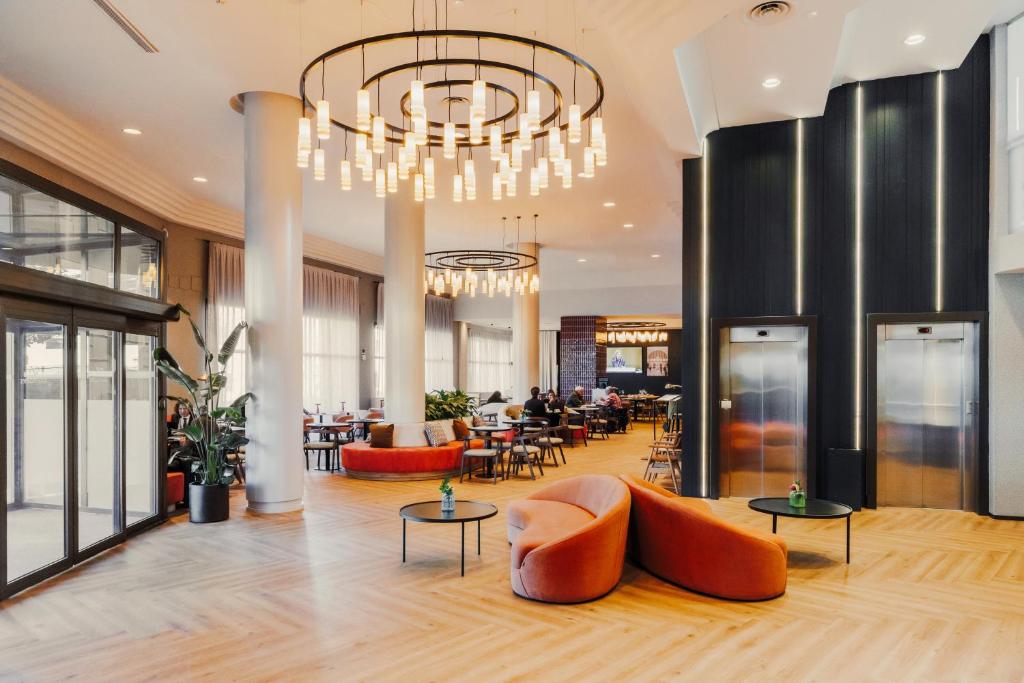 a lobby with tables and chairs and a chandelier at Rafaelhoteles Atocha in Madrid
