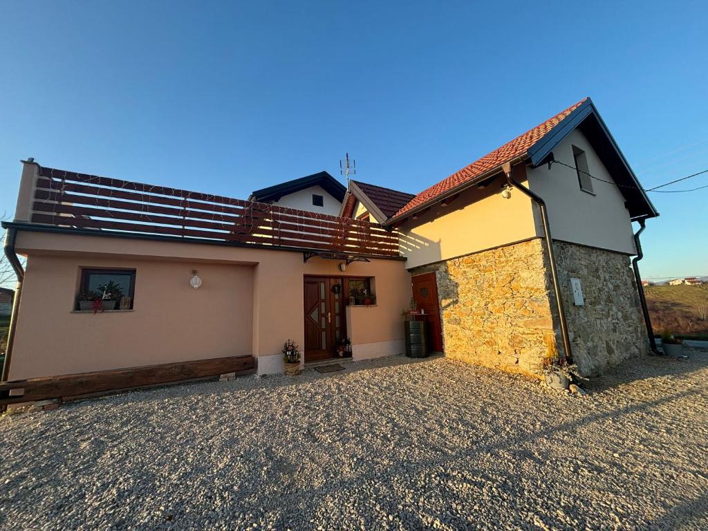 a house on a gravel road next to a building at Kuća za odmor Velnira in Ozalj