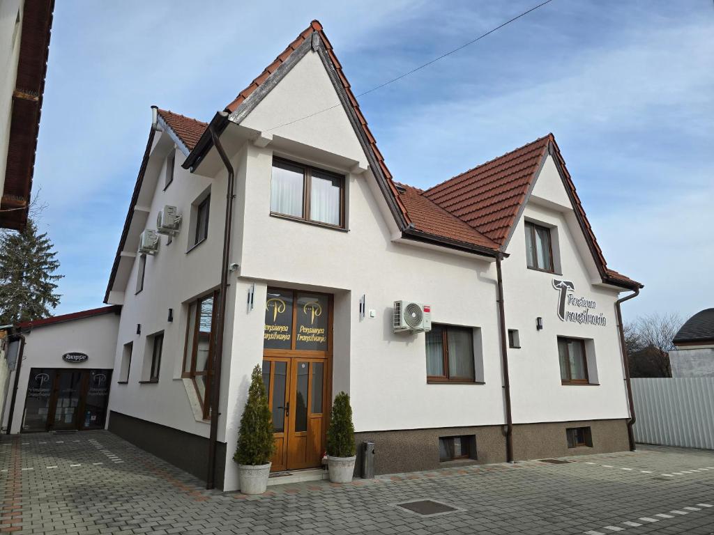 a white building with a brown roof at Pensiunea Transilvania in Sibiu