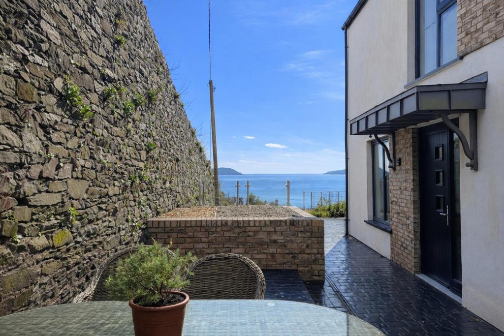 a patio with a table and a stone wall at 14 Dun Farraige in Cobh