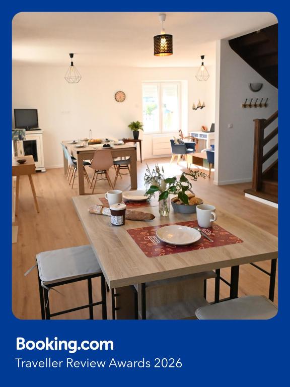 a dining room and living room with a wooden table at L'Auberge Du Roch in Saint-Pierre-Quiberon