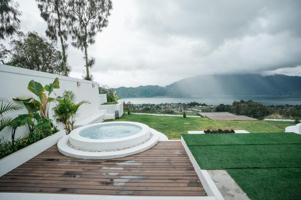 a hot tub sitting on top of a wooden deck at Glamor Kintamani in Kubupenlokan