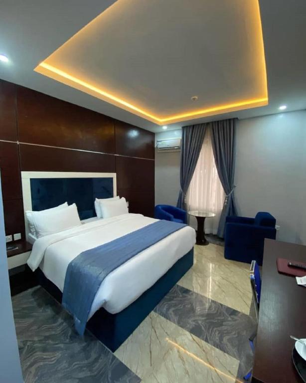 a hotel room with a large bed and a desk at Chinbell Luxury Hotel & Suites in Lekki