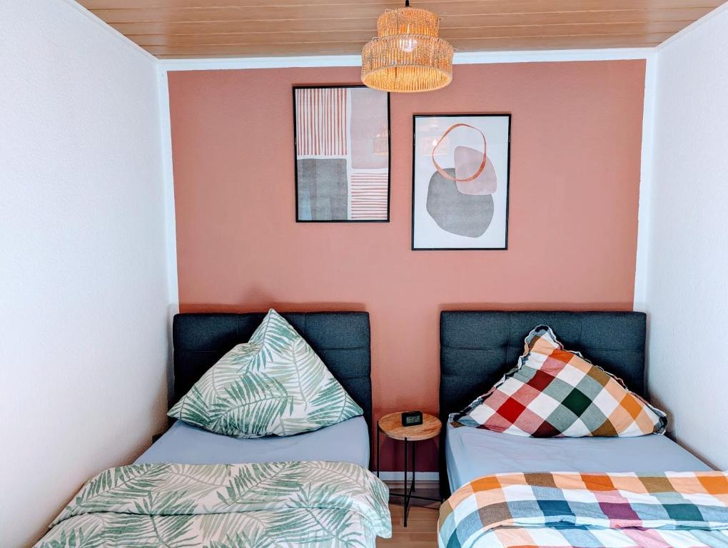two beds in a room with pink walls at Wat Bickenbach in Bickenbach