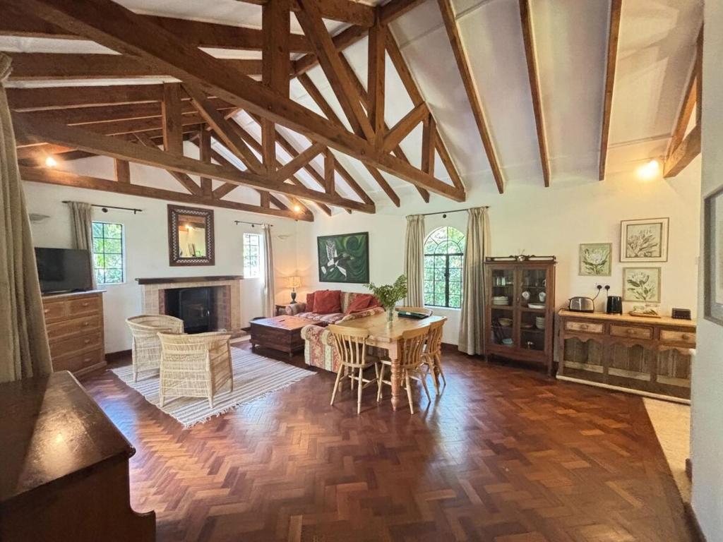 a large living room with a table and a couch at Hornbill Cottage in Nairobi