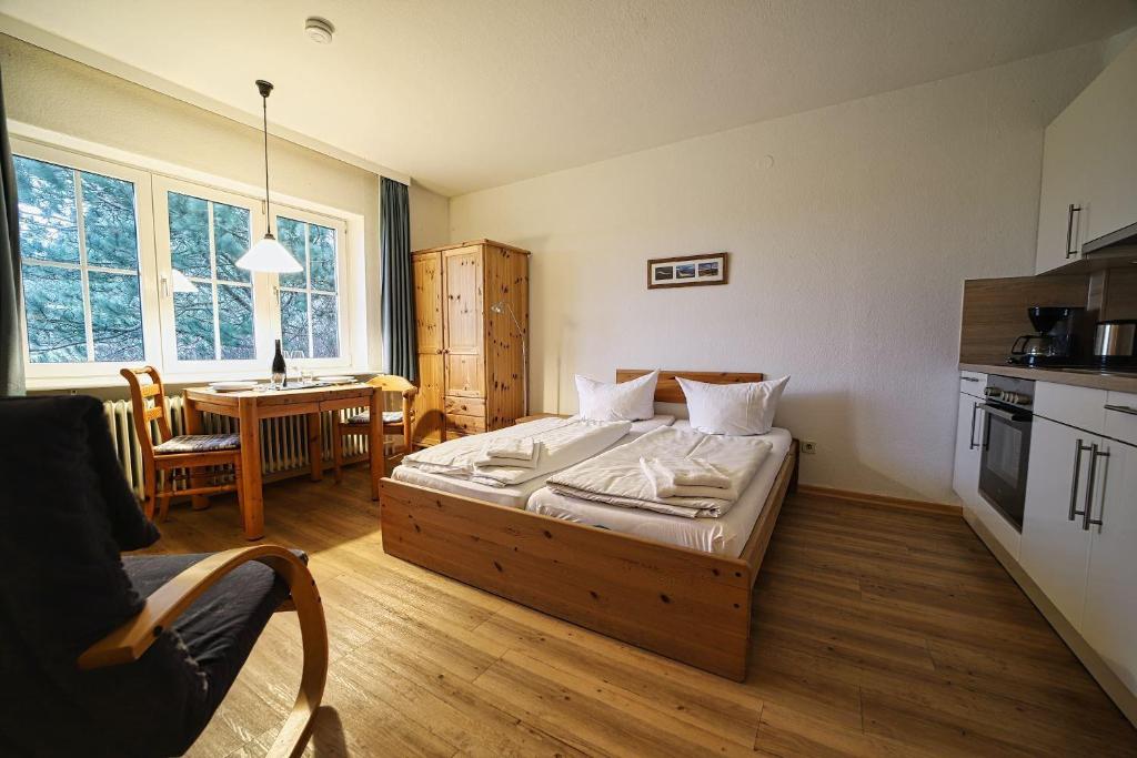 a bedroom with a bed and a kitchen and a table at Appartement-4 in Süddorf