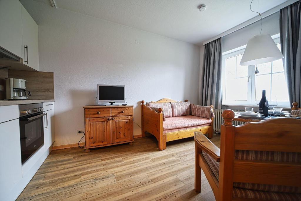 a living room with a couch and a tv on a table at Appartement-3 in Süddorf